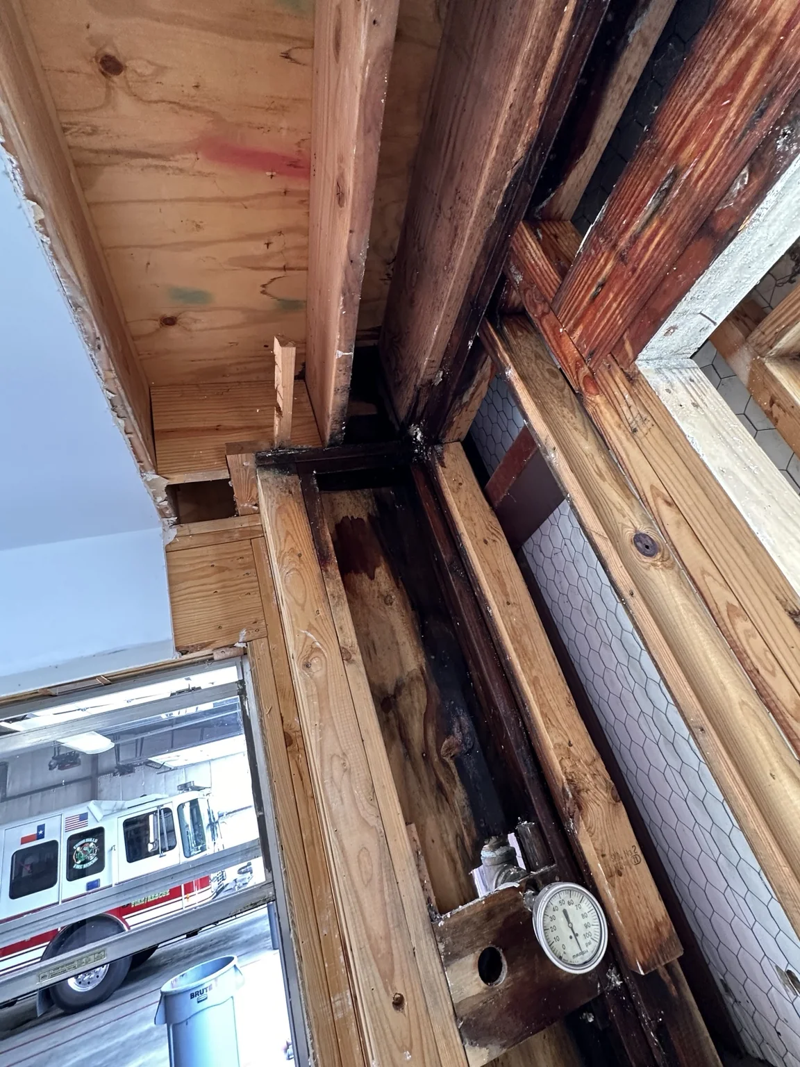 Exposed wall framing during Same Day Mitigation water-loss work at a municipal fire station
